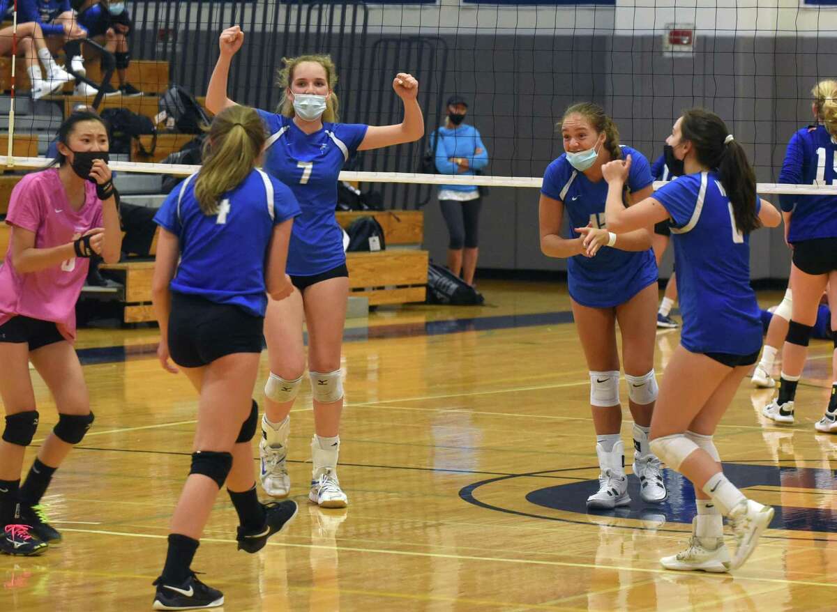 The Darien Blue Wave celebrates a point against Newtown during a girls volleyball match in Darien on Monday, Sept. 13, 2021.