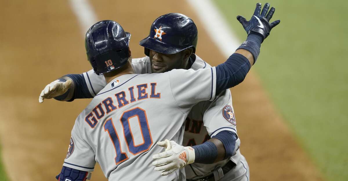 Houston Astros fan Mark McKee, of Beaumont, Texas, celebrates as he watches  the Astros' Yuli Gurriel (10) congratulate Yordan Alvarez (44) on his  two-run home run as umpire Larry Vanover stands by