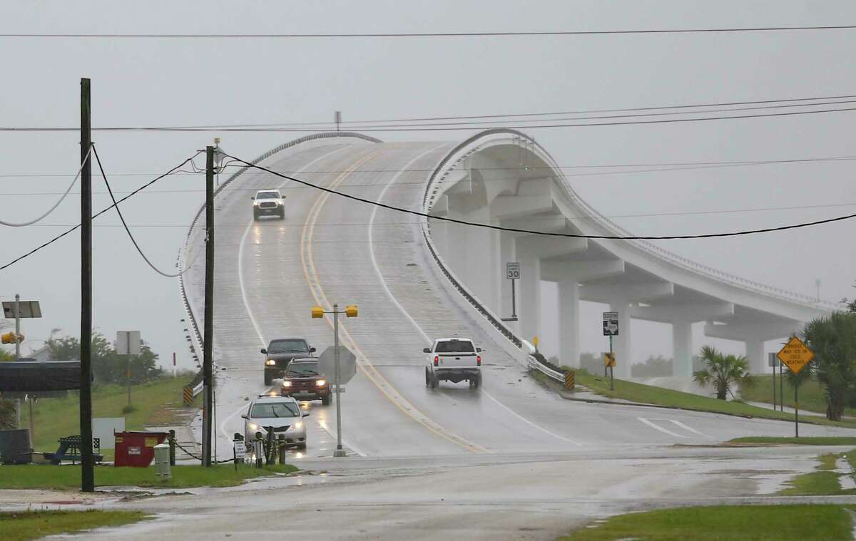 Vehicles make their way over the Intracoastal Waterway Bridge in Matagorda, Texas as Tropical Storm Nicholas approaches on Monday, Sept. 13, 2021. (Elizabeth Conley/Houston Chronicle via AP)