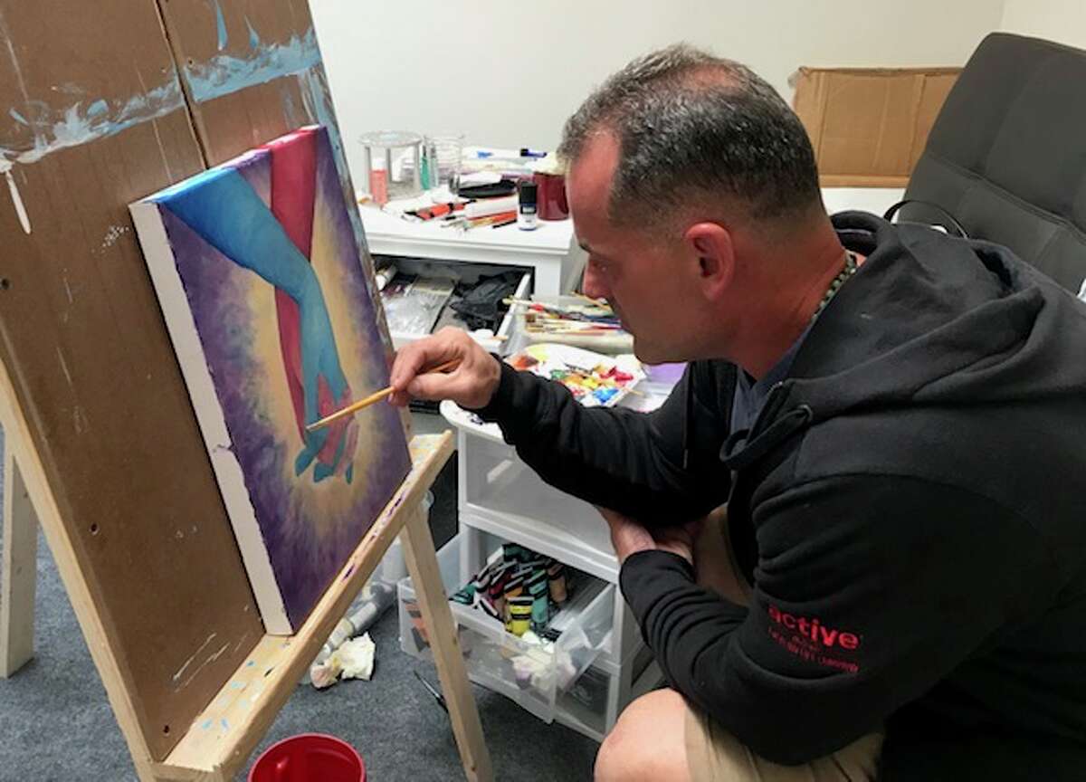 Artist John Zoccoli, who spent 25 years in prison on a robbery and murder conviction, works on a painting in the studio of his Albany apartment. 
