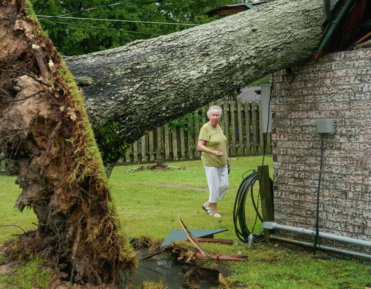 Marie Davis looks at the damage caused by a tree which was knocked over into her home during Tropical Storm Nicholas, on Tuesday, Sept. 14, 2021, in Baytown. This is the third time a tree has falle into Davis' home; hurricanes Alicia and Ike were the prior two occurrences.