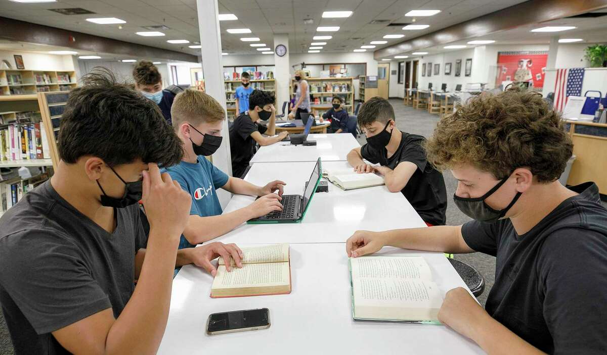 Freshman students, from left to right, Ryan Smith, Finian Hickey, Gordon Johns, and Tyler Selitte study in the media center on the first day of school at Cheshire High School, Tuesday, Aug. 31, 2021, in Cheshire, Conn.(Dave Zajac/Record-Journal via AP)