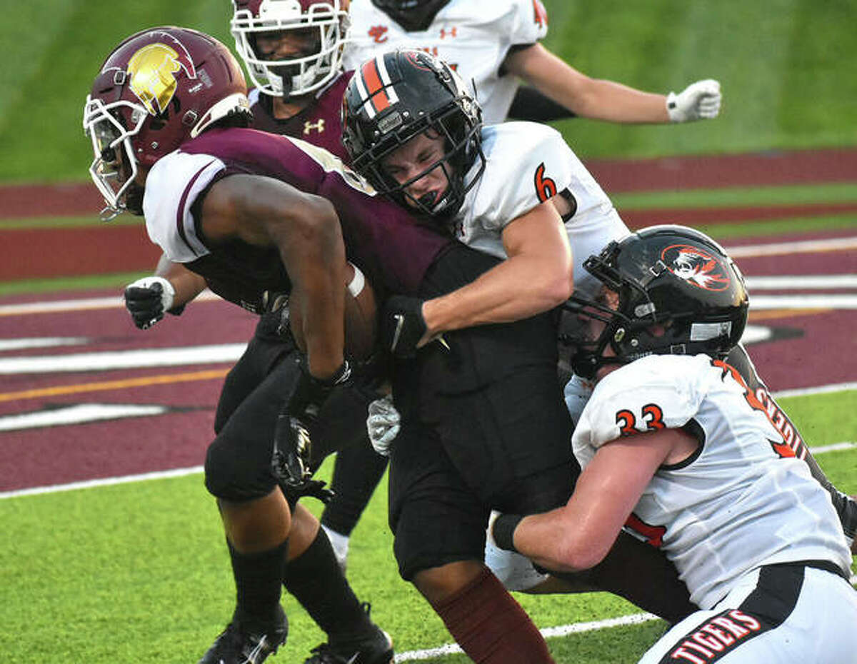 Edwardsville cornerback Carter Knoyle, top, and Dalton Brown, bottom, combine to make a tackle against De Smet during Week 1.