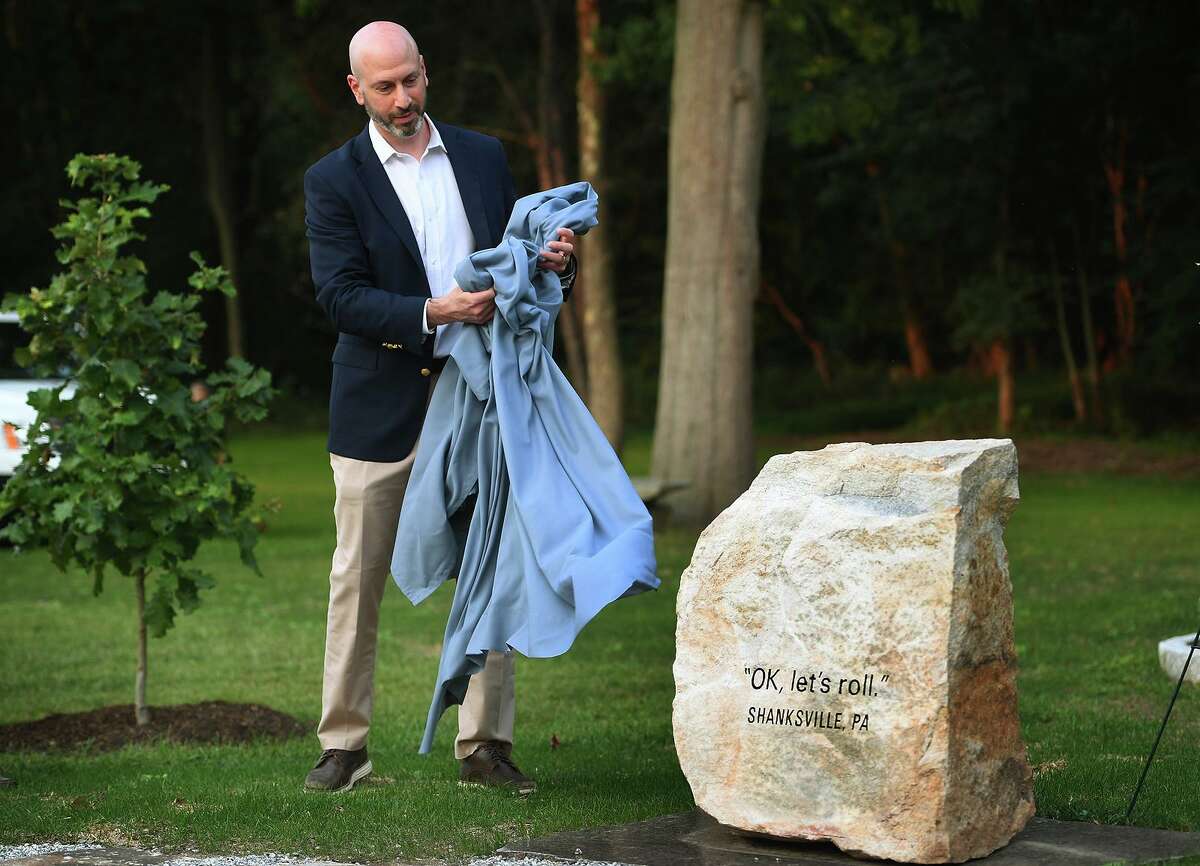 Jed Glick, brotther of Jeremy Glick, hero of United Airlines Flight 93, unveils a section of the new 9/11 memorial at Oak Lawn Cemetary & Arboretum in Fairfield on Tuesday.