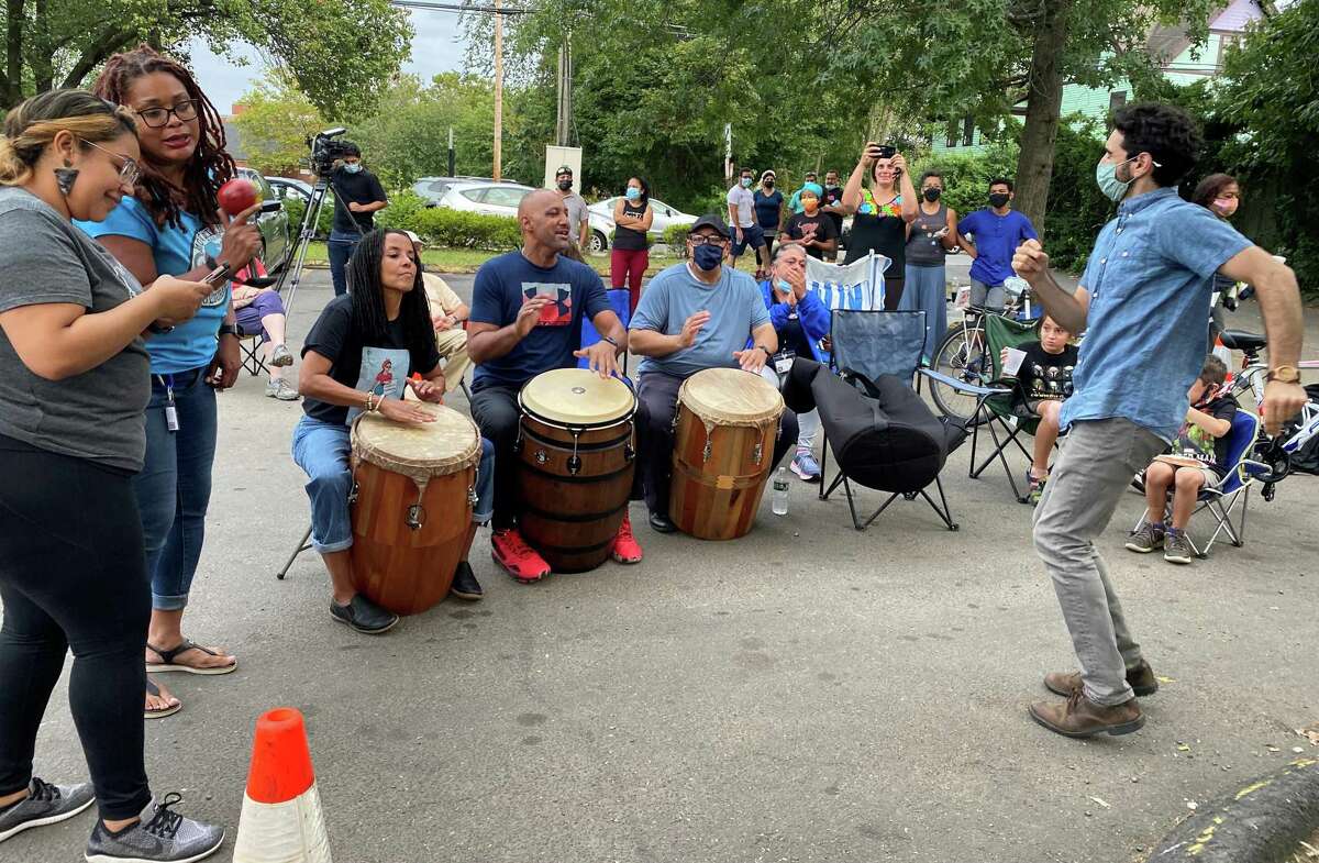 David Weintraub dances as Kica Maros, Alex Rosado and Kevin Diaz play the drums in New Haven’s Fair Haven, where neighbors are working together to end violence.