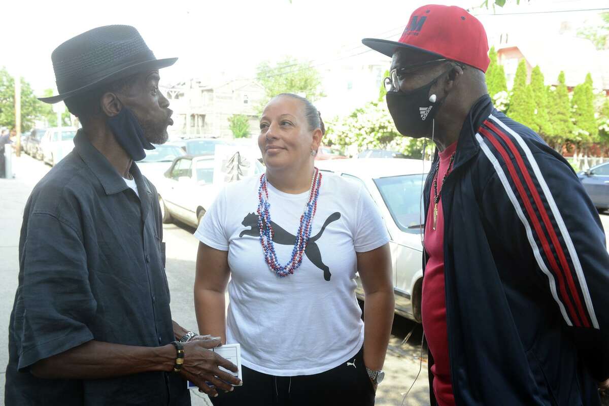 City Council member Eneida Martinez stands with fellow councilman Ernie Newton, left, and Henry Webb outside Dunbar School in Bridgeport on Tuesday.