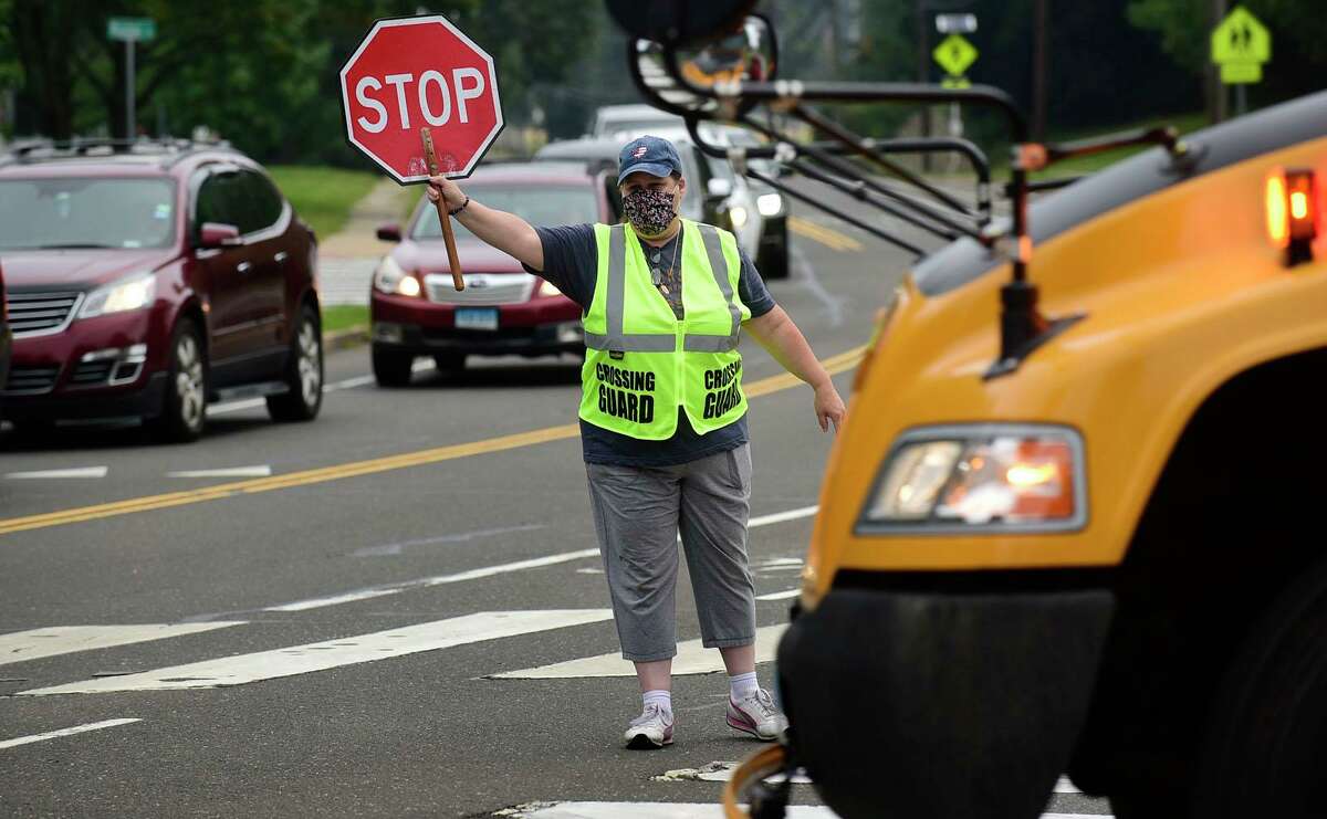 A crossing guard stops traffic on King Street near Naramake, Nathan Hale and Norwalk High Schools, that backs up on Strawberry Hill Wednesday, September 15, 2021, in Norwalk, Conn. Norwalk Public Schools in considering changing start times to ease congestion.