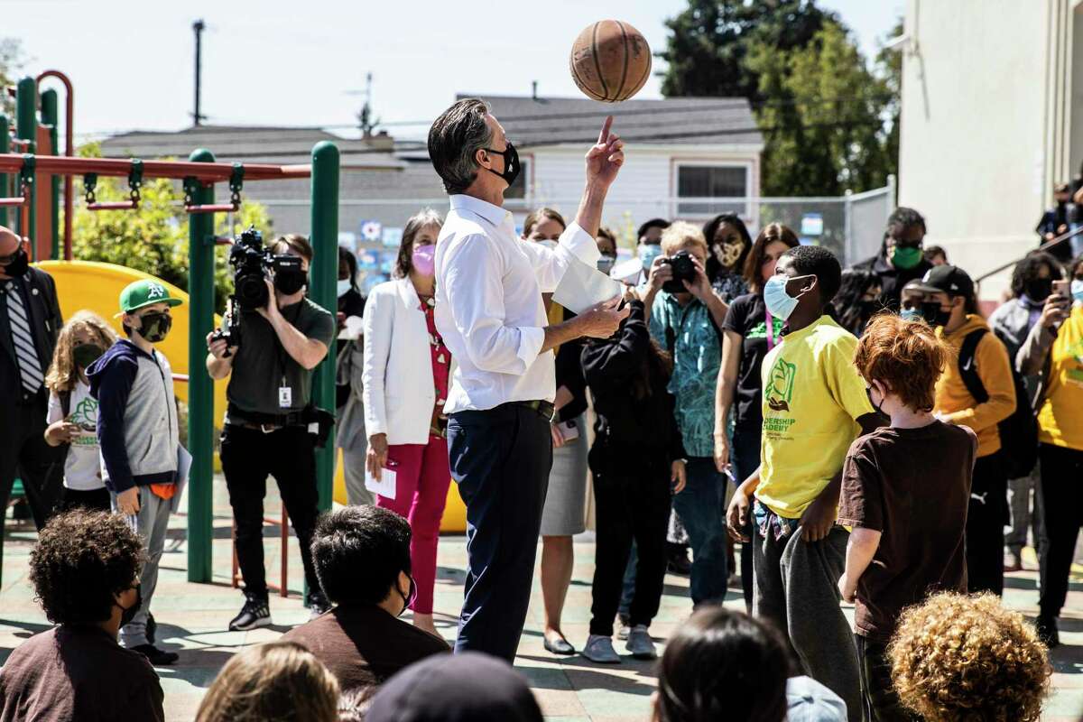 California Governor Gavin Newsom spins a basketball during a visit at Melrose Leadership Academy the day after surviving the gubernatorial recall election in Oakland, California Wednesday, Sept. 15, 2021.