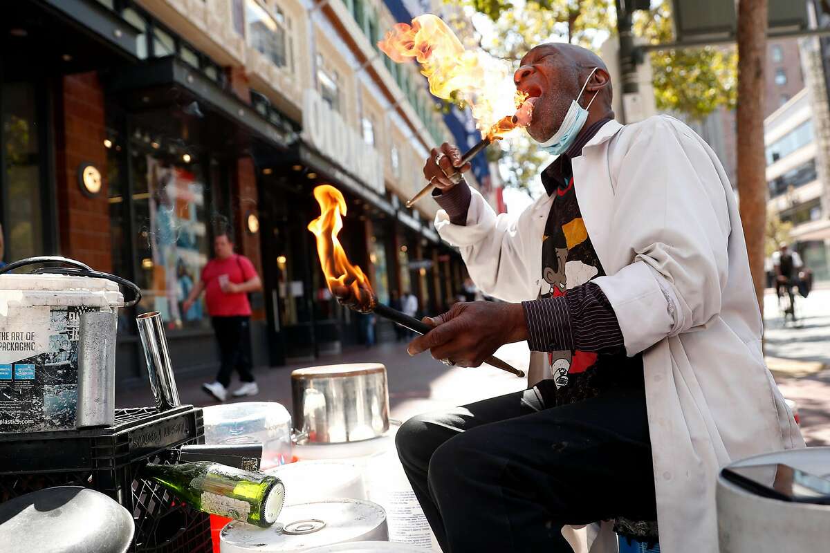Larry Hunt, The San Francisco Bucket Man, plays with flaming drumsticks on Market Street in San Francisco, Calif., on Thursday, August 26, 2021.