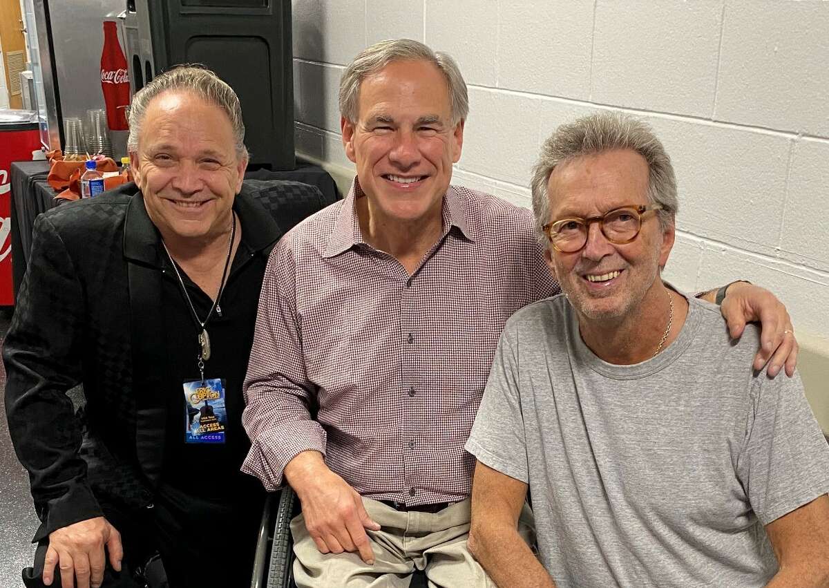 Gov. Greg Abbott posed for a photo mask-less backstage alongside Eric Clapton and Jimmie Vaughan following a concert Wednesday night in Austin. 