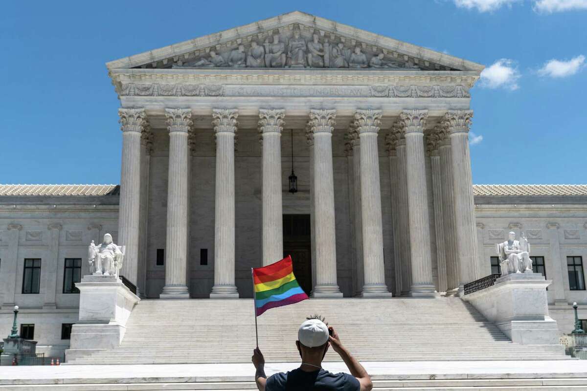 A person waves a rainbow flag in front of the Supreme Court in Washington, on Monday, June 15, 2020. The Supreme Court ruled Monday that a landmark civil rights law protects gay and transgender workers from workplace discrimination, handing the movement for LGBTQ equality a stunning victory. (Anna Moneymaker/The New York Times)
