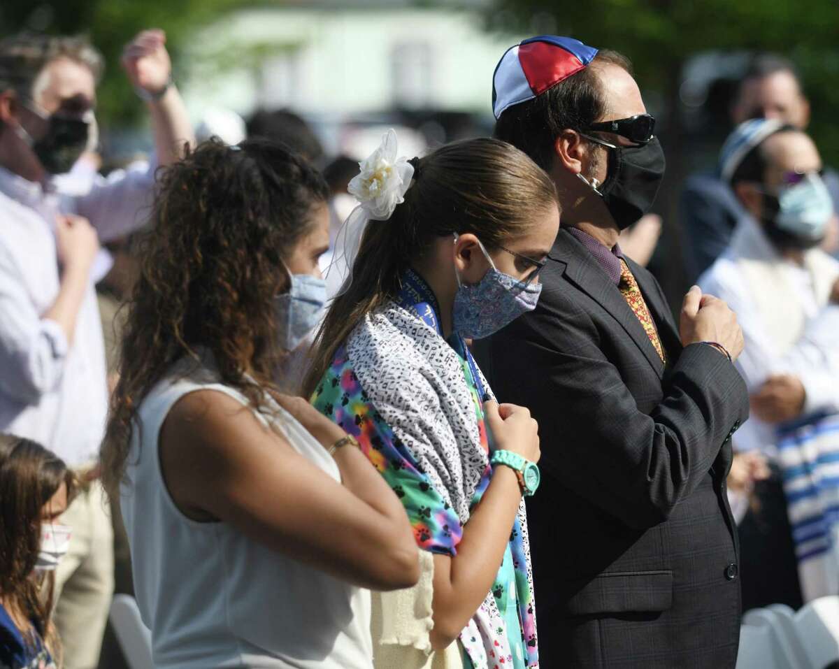 People participate in Vidui's confessional by patting their breasts during the Yom Kippur family service at the Greenwich Reform Synagogue in Greenwich, Connecticut on Thursday, September 16, 2021. Worshipers celebrated Yom Kippur, the Jewish Day of Atonement , with a variety of readings and songs.