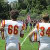 A pair of players from the Gilbert/Northwestern/Housatonic co-op footbal lteam stand at attention during the national anthem before a recent game.
