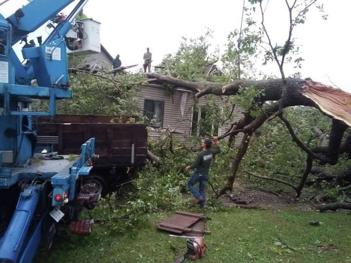 The family of Cathy and Alan Kerns wasted no time in helping to remove a huge oak tree which crashed through the roof and ceiling of their home. (Courtesy photo) 