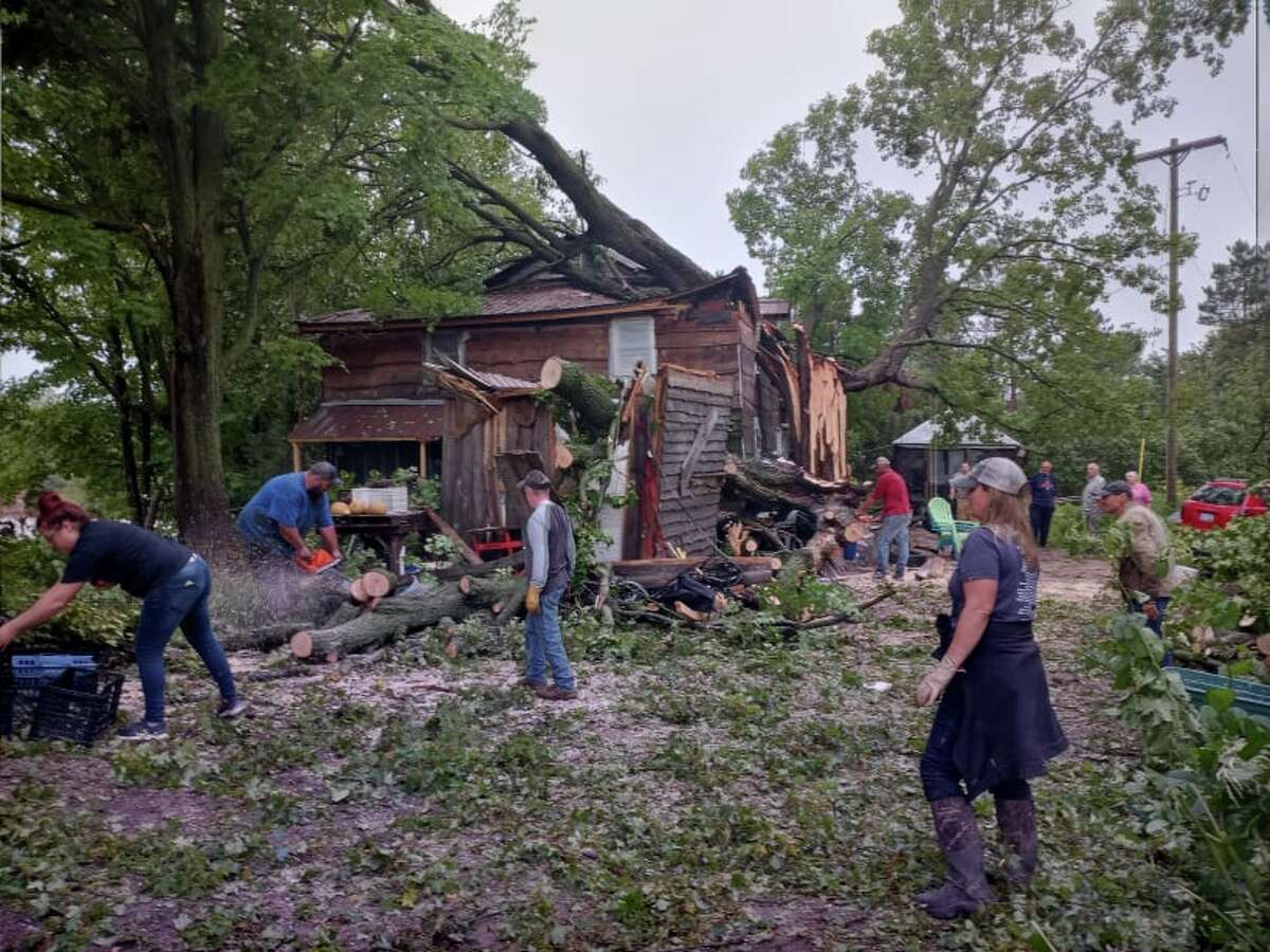 Neighbors and friends gathered at the Tiki Hut in Chase right after the storm, to help clean up damage where a large maple crashed through the roof on a home on the property. (Star photo/Shanna Avery) 
