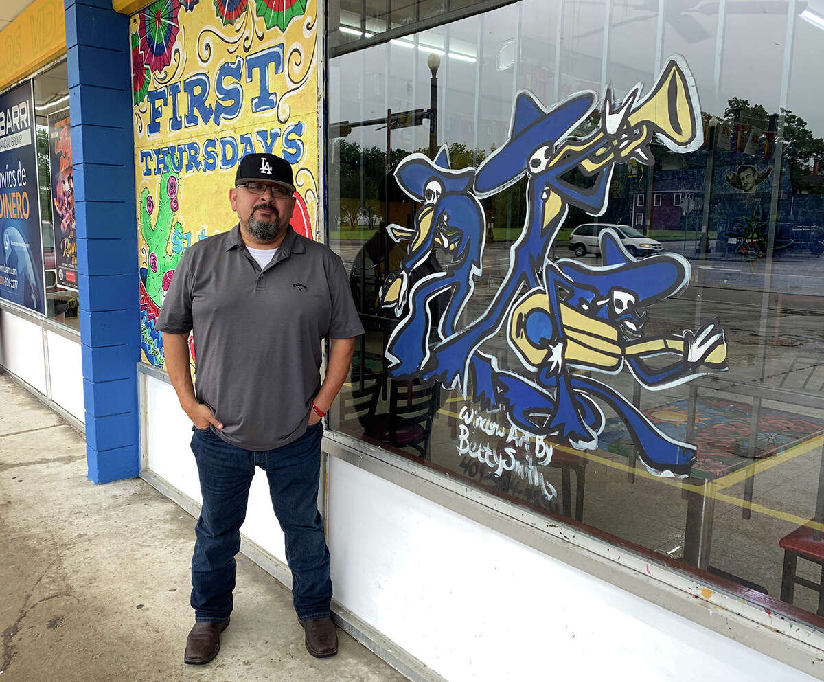 Carlos Zuniga with Betty Smith's painted window at Tacos La Bamba. Photo by Andy Coughlan