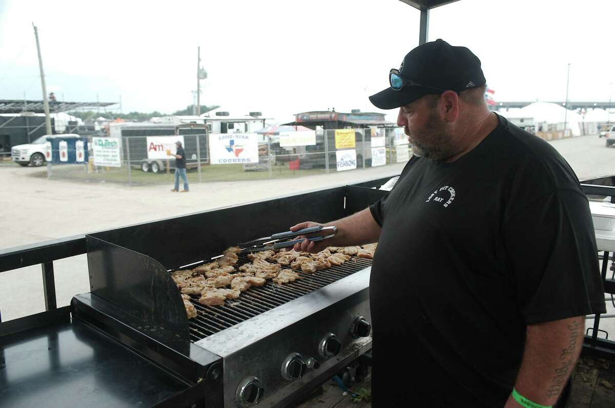 Ray Curry of Lost Pit Cookers tends to a grill full of chicken fajitas he is preparing for guests at his booth.