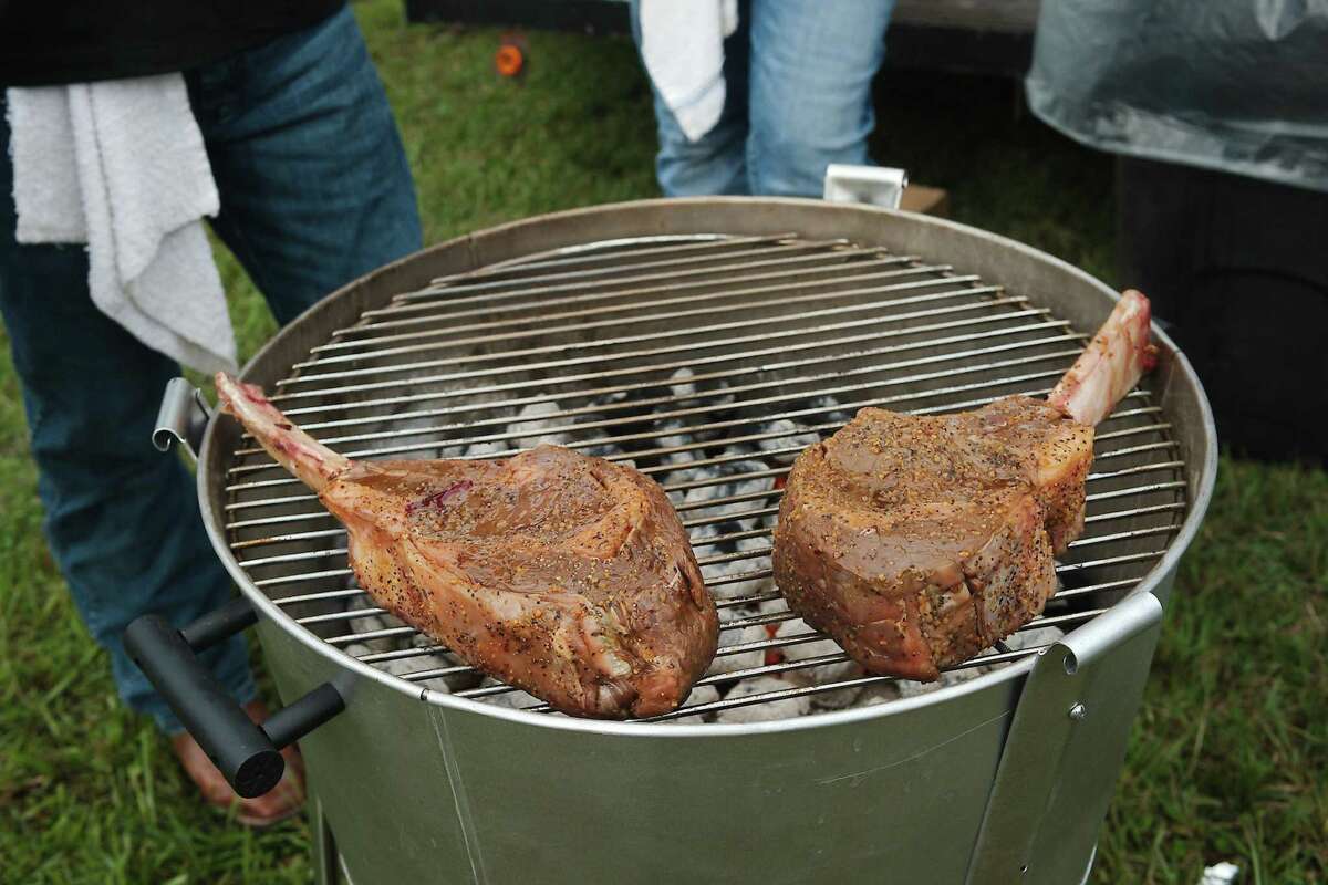 Very large tomahawk steaks sit on the grill at the N-Flames booth.
