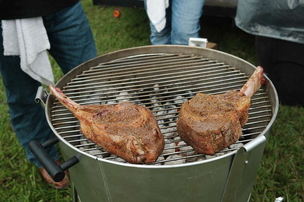 Very large tomahawk steaks sit on the grill at the N-Flames booth at last year's cookoff competition.