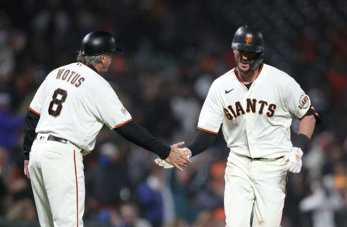 Kris Bryant of the San Francisco Giants is congratulated by third base coach Ron Wotus after he hit a home run in the sixth inning against the San Diego Padres.