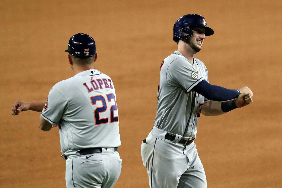 Third base coach Omar Lopez #22 celebrates the solo home run by Kyle Tucker of the Houston Astros in the eighth inning against the Texas Rangers at Globe Life Field on September 15, 2021 in Arlington.