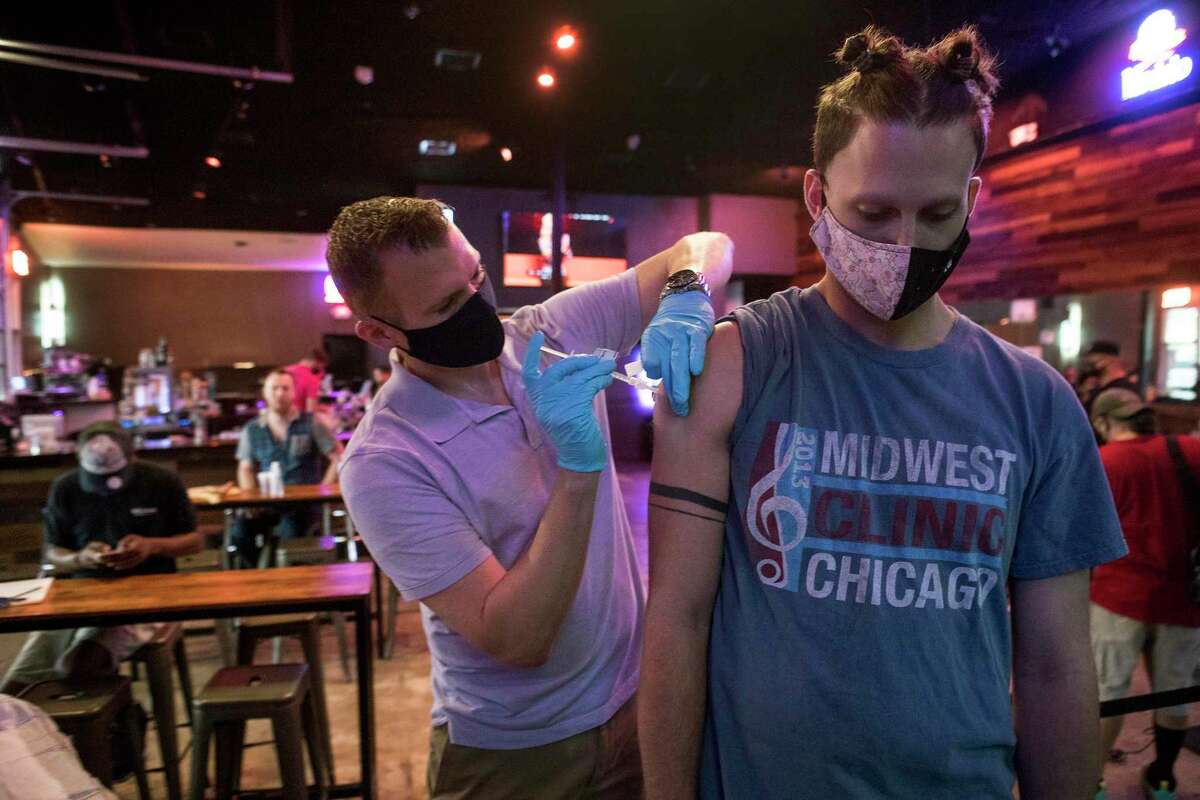 Ruston Taylor administers a dose of Moderna COVID-19 vaccine to Austin Houghton during a pop-up vaccination clinic at BUDDY'S Houston in Montrose on Thursday, April 29, 2021 in Houston. BUDDY'S teamed up with Wellness Bar by Legacy to offer vaccines by appointment.