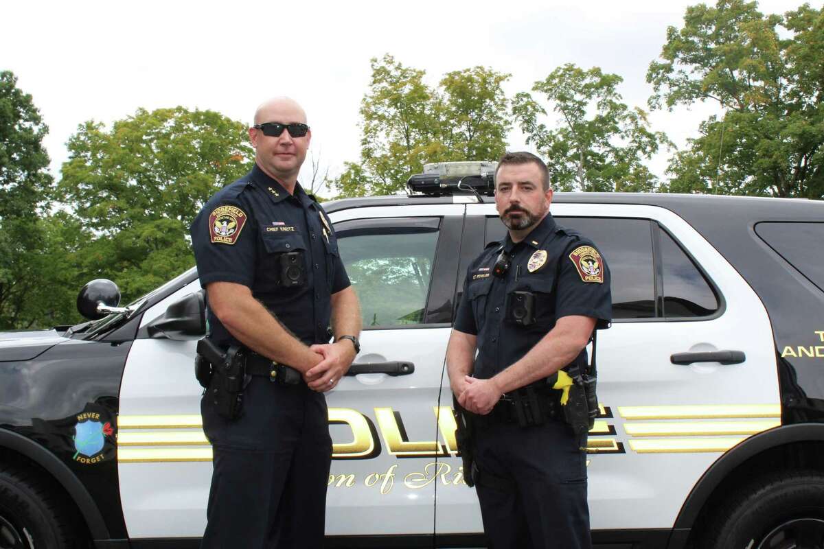 Ridgefield Police Chief Jeff Kreitz, left, and Lt. Nick Fowler stand in front of a patrol car that is outfitted with an Axon dashboard camera. The department rolled out both in-car and body cameras earlier this month to comply with the state’s police accountability bill mandate.