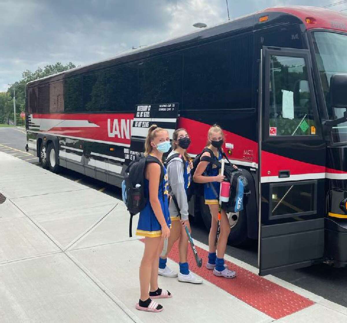 The Brookfield field hockey team boards a coach bus the Bobcats had to use to a game at Nonnewaug in Woodbury on Tuesday. Brookfield is one of many school districts that have had to find alternative modes of transportation due to a bus shortage.
