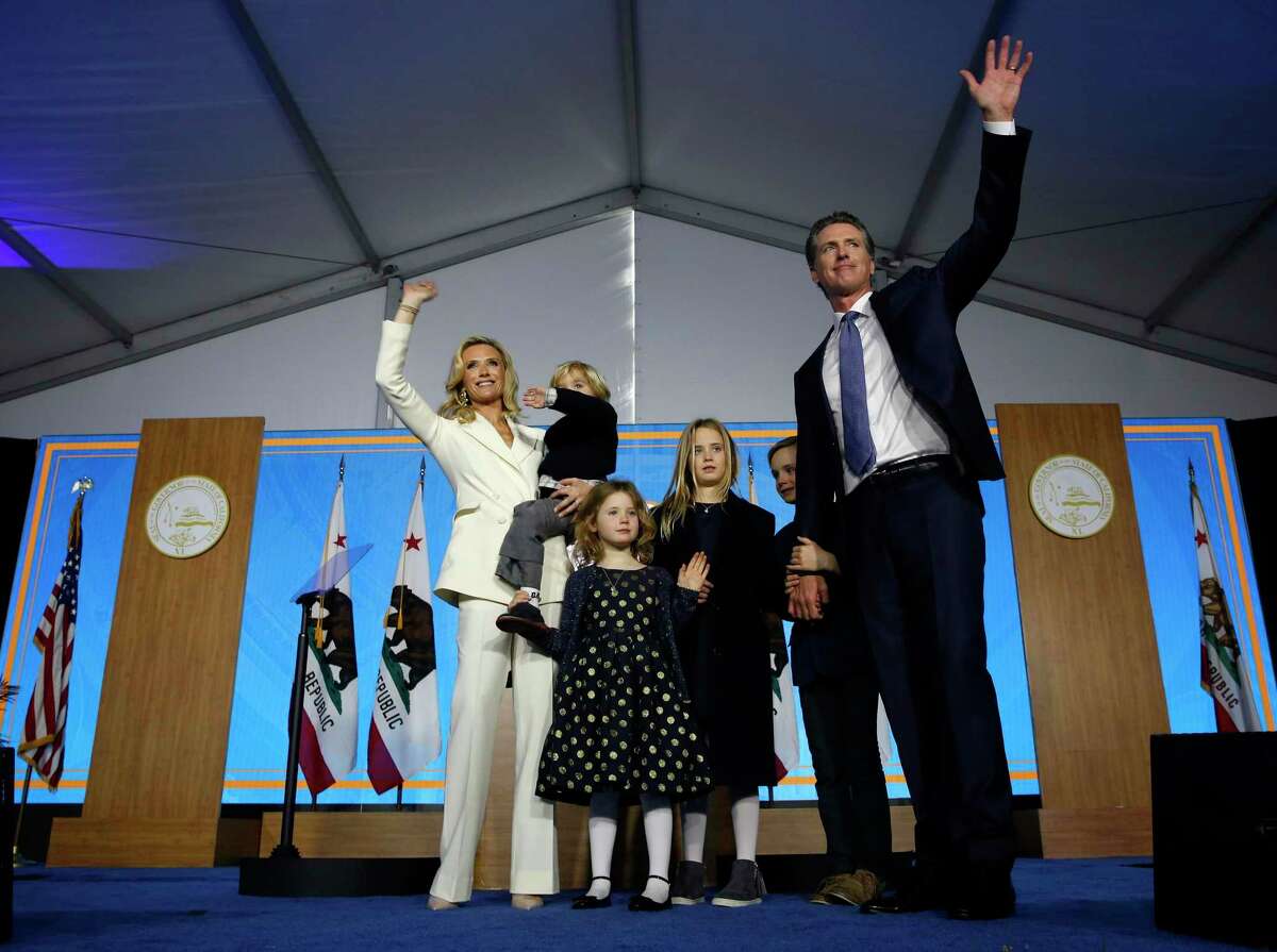 FILE -- In this Jan. 7, 2019 file photo, California Gov. Gavin Newsom, his wife, Jennifer Siebel Newsom, and family waves after taking the oath office during his inauguration as the 40th Governor of California, Sacramento, Calif. (AP Photo/Rich Pedroncelli, File)