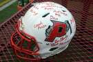 A signed football Pomperaug High School football helmet was presented to Ryan Rutledge’s parents prior to a game in Southbury, Conn. Sept. 17, 2021.