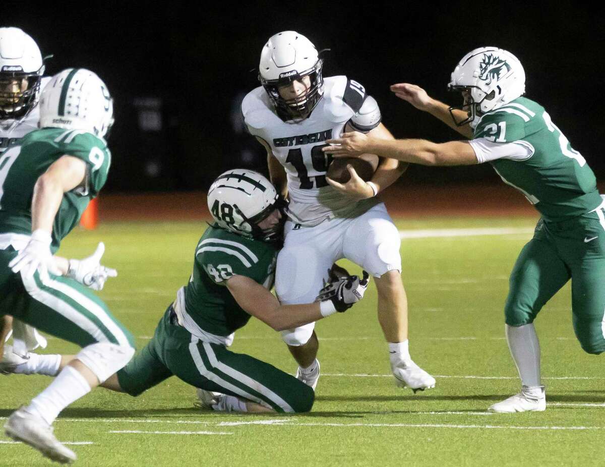 Cistercian quarterback Dan O'Toole (19) is tackled down by Jon Cooper Connor Dove (48) and Owen Baadsgaard (21) during the first quarter of a Southwest Prep 3A football game at The Woodlands Christian Academy, Friday, Sept. 17, 2021, in The Woodlands.
