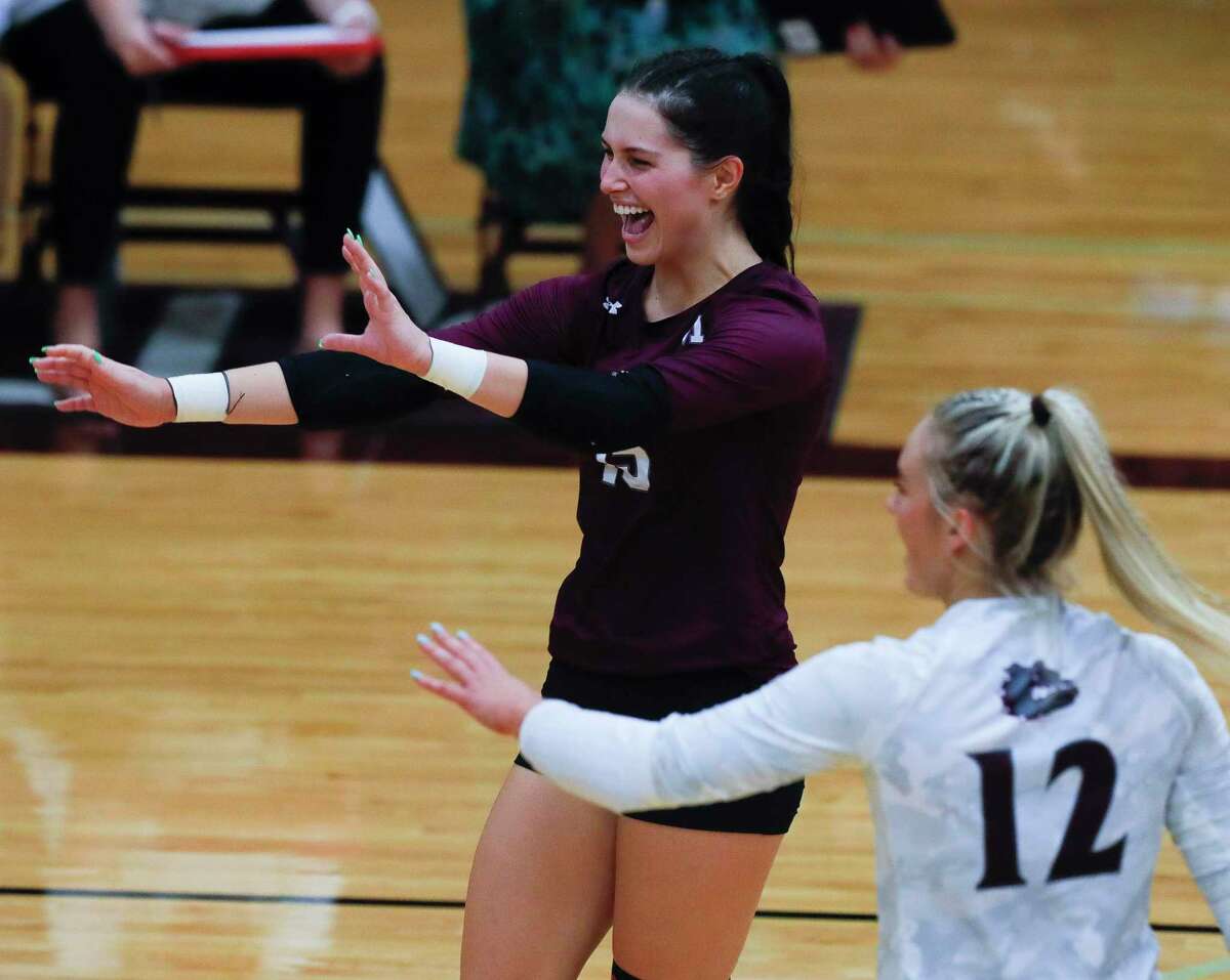 Magnolia libero Kaylyn Fojt (15) and outside hitter Sydney Gentry (12) react after an ace by outside hitter Kaylee Kelton (1) in the second set during a high school volleyball match at Magnolia High School, Tuesday, Aug. 24, 2021, in Magnolia.