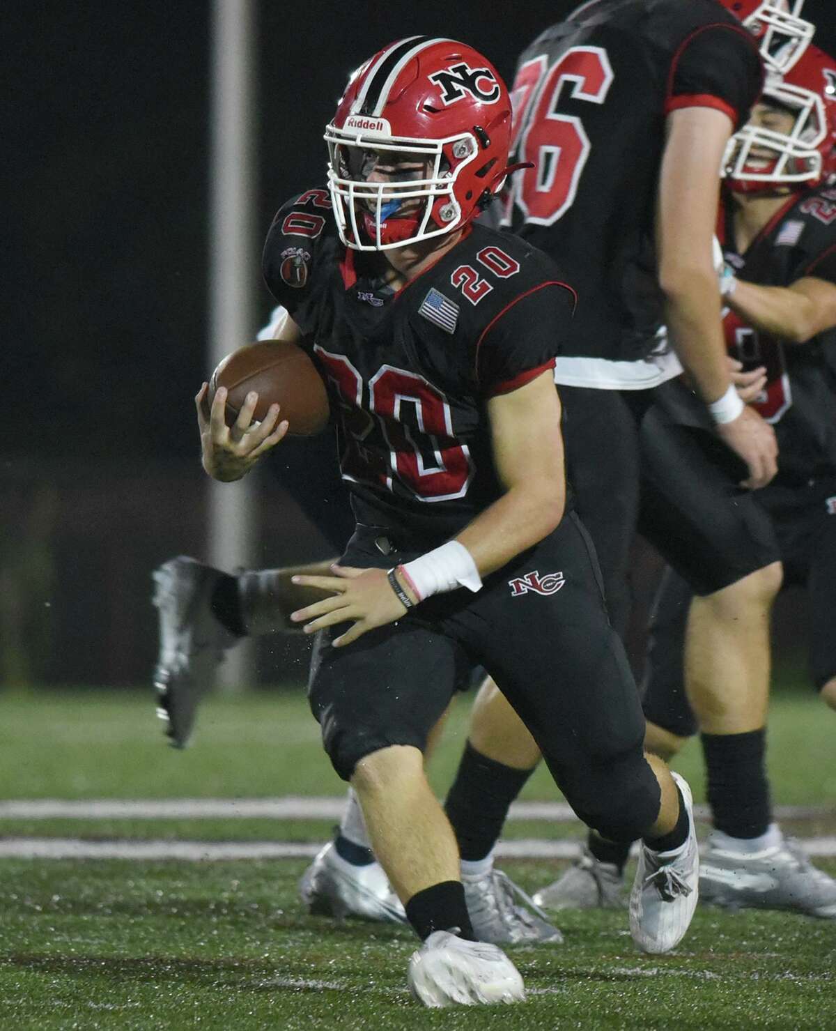 New Canaan’s Conor Bailey (20) runs for a few yards against Brien McMahon during a football game at Dunning Field in New Canaan on Friday, Sept. 17, 2021.