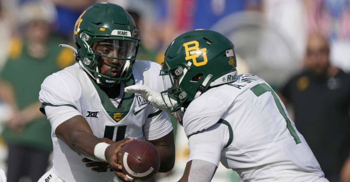 Baylor quarterback Gerry Bohanon (11) hands the ball to running back Abram Smith (7) during the second half of an NCAA college football game against Kansas in Lawrence, Kan., Saturday, Sept. 18 2021. Baylor defeated Kansas 45-7. (AP Photo/Orlin Wagner)