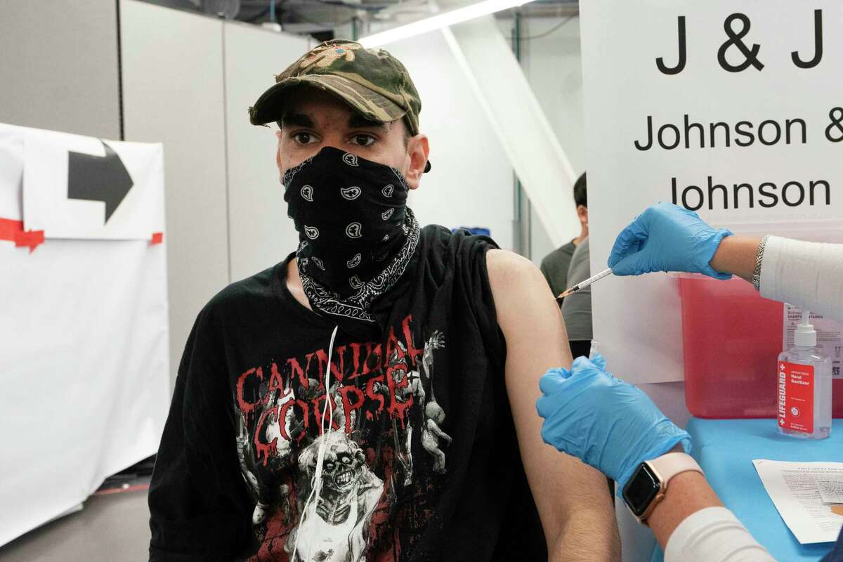 FILE - In this July 30, 2021, file photo, Jay Vojno gets the Johnson & Johnson COVID-19 vaccine, in New York. In both the U.S. and the EU, officials are struggling with the same question: how to boost vaccination rates to the max and end a pandemic that has repeatedly thwarted efforts to control it. In the United States, President Joe Biden has issued sweeping vaccine mandates.