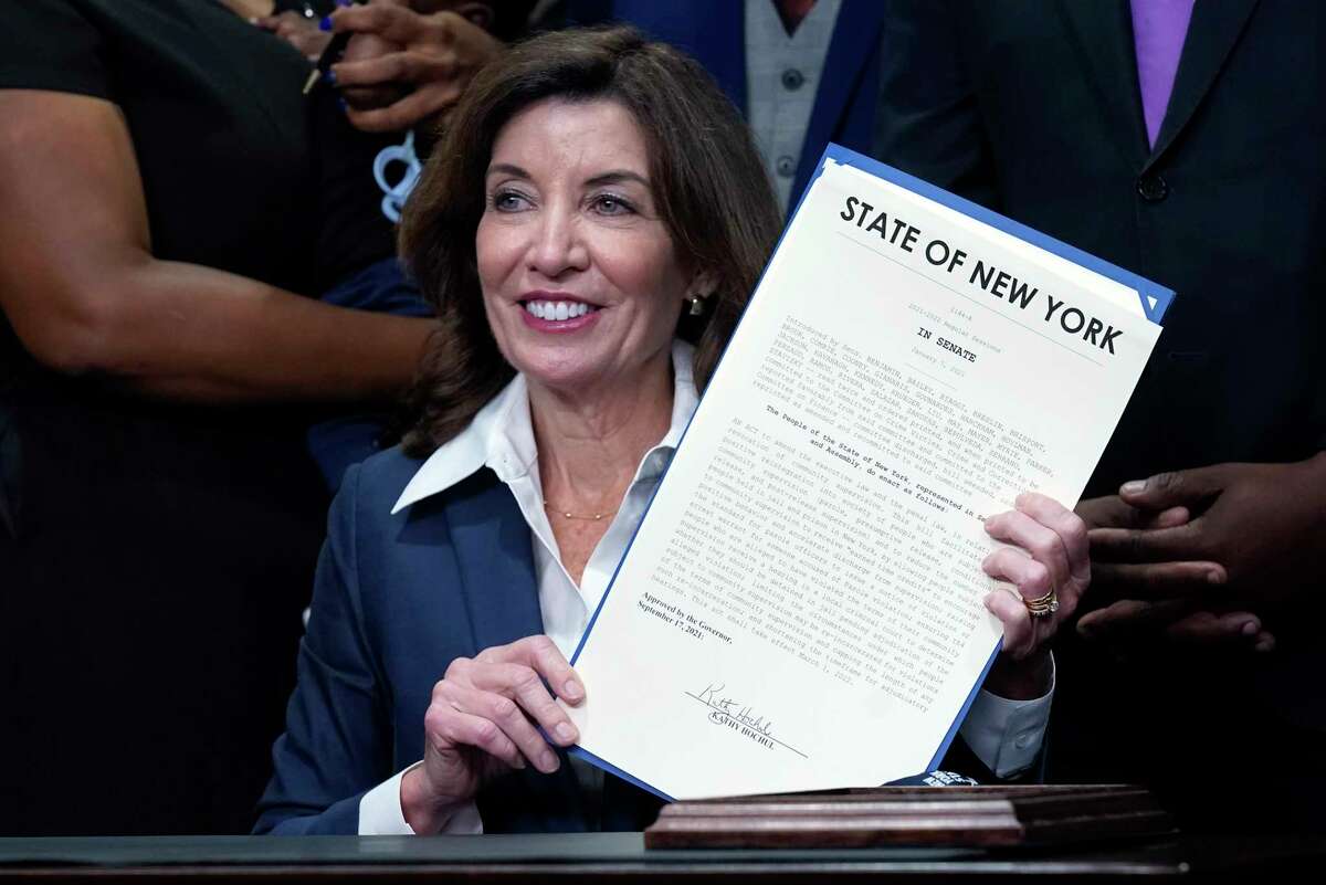New York Gov. Kathy Hochul holds the "Less is More" law she signed, during ceremonies in the her office, in New York, Friday, Sept. 17, 2021. New Yorkers will be able to avoid jail time for most nonviolent parole violations under a new law that will take effect in March, and largely eliminates New York's practice of incarcerating people for technical parole violations. (AP Photo/Richard Drew)
