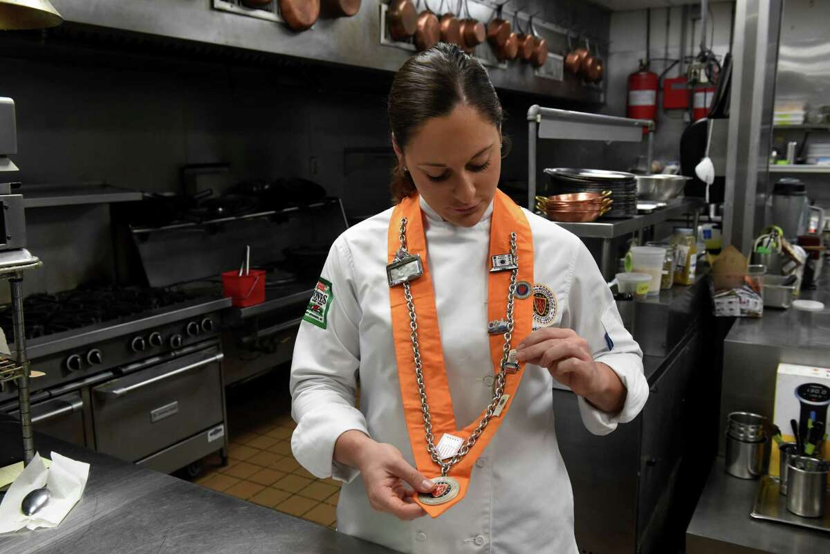 Chef Gabriella O'Neil of Albany points out some her culinary accolades displayed on a sash on Thursday, Sept. 9, 2021, at Yono's, dp An American Brasserie in Albany N.Y. O?•Neil a few months ago won the U.S competition for young chefs sponsored by the international culinary organization Chaine des Rotisseurs. In late September she will be the sole competitor representing the U.S. in a Chaine cook-off in Paris. The Albany native graduated from the Culinary Institute of America in Hyde Park.