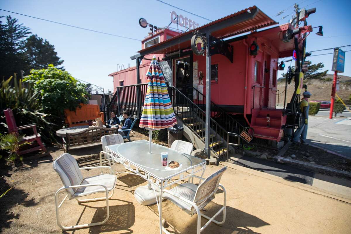 Customers enjoy the outdoor seating at P-Town Coffee and Tea, located in a train caboose, in Pacifica, Calif.
