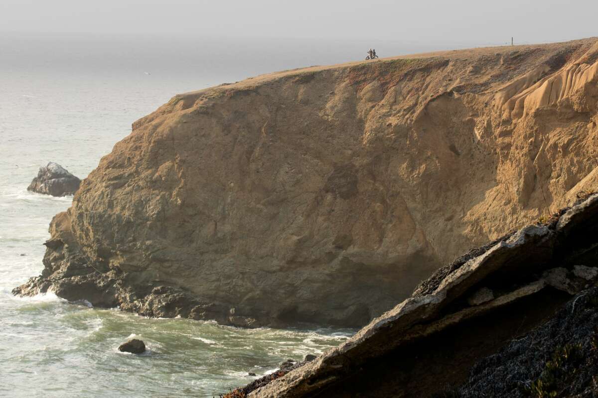 Two bicyclists take in the view of the shoreline along the Mori Point Loop Trail in Pacifica, Calif., on Sept. 15, 2021.