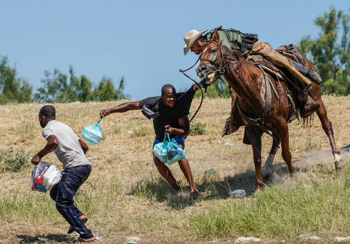 A Texas border patrol agent on horseback tries to stop a Haitian migrant from entering an encampment on the banks of the Rio Grande near the Acuna Del Rio International Bridge in Del Rio, Texas on September 19, 2021.