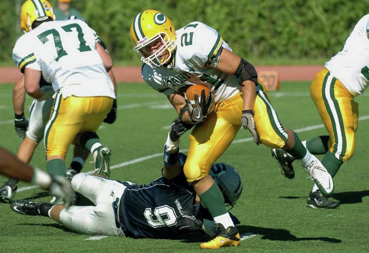 Football game action between Trinity Catholic and Staples High Schools in Westport, Conn. on Friday September 17, 2010. Trinity Catholic #21 Mike Rivas slips from the grasp of Staples #9 Patrick Murray.