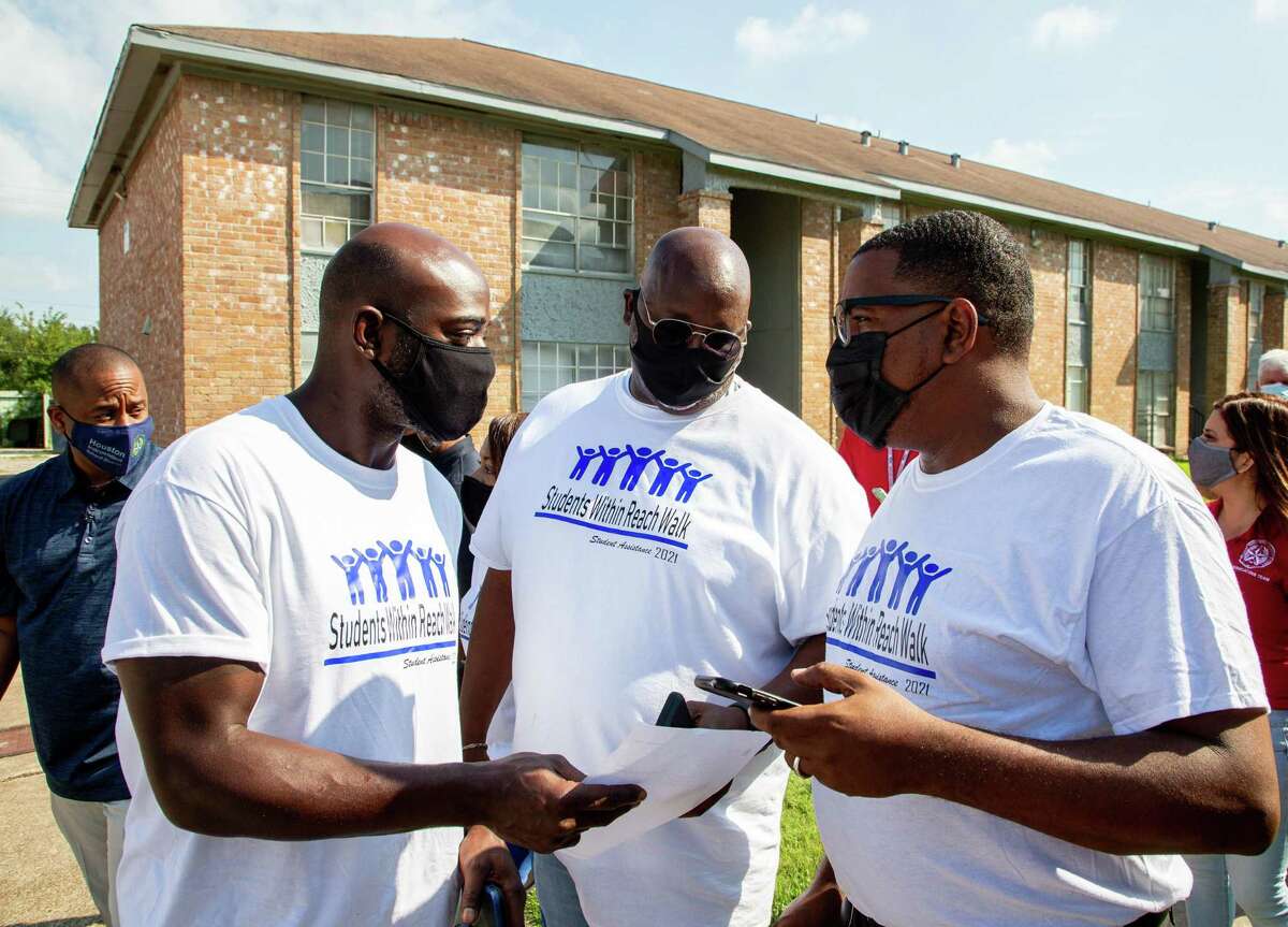 Superintendent Millard House II, left, along with Houston ISD staff and community volunteers, were knocking on doors to personally encourage students to return to school during the annual “Students Within Reach Walk” on Saturday in Houston.