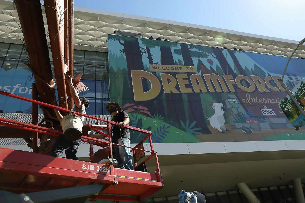 Eksel Perez (left), installer and Robert Schmitt, installer/decorator, work on the set up of Salesforce's Dreamforce 2021 conference as they work on Howard Street in San Francisco.