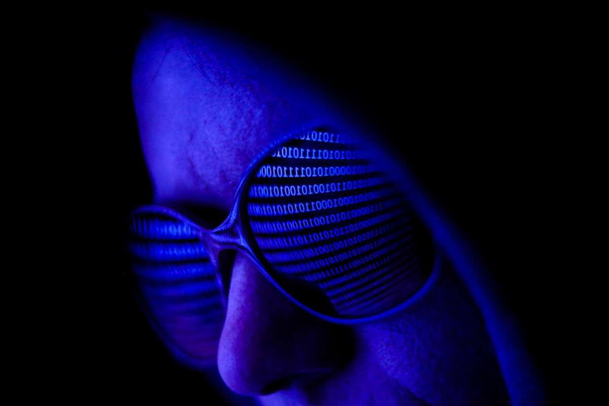 Binary code displayed on a laptop screen is reflected in the sunglasses in this illustration photo taken in Krakow, Poland on August 17, 2021. (Photo by Jakub Porzycki/NurPhoto via Getty Images)