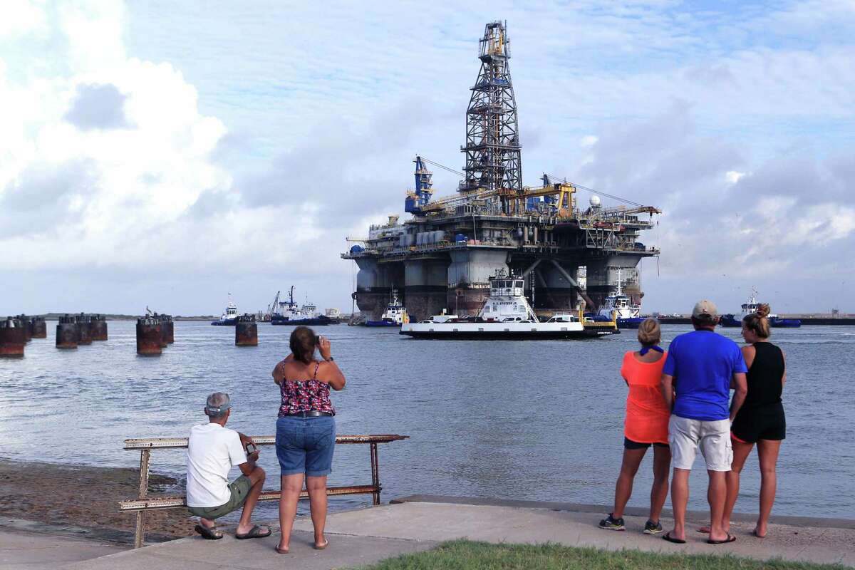 Richard Jones (from left) Dee Dee Cruz, Tane McGehee, Dennis McGehee and Mollie McGeehee watch as the Noble Jim Day, one of the world's largest offshore oil rigs, travels through the ship channel on Thursday, July 28, 2016 in Port Aransas. The rig was docked at Gulf Copper.