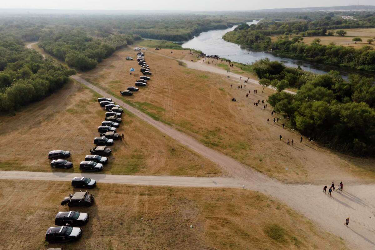 Official vehicles line up along the bank of the Rio Grande near an encampment of migrants, many from Haiti, near the Del Rio International Bridge, Tuesday, Sept. 21, 2021, in Del Rio, Texas. The U.S. is flying Haitians camped in a Texas border town back to their homeland and blocking others from crossing the border from Mexico. (AP Photo/Julio Cortez)