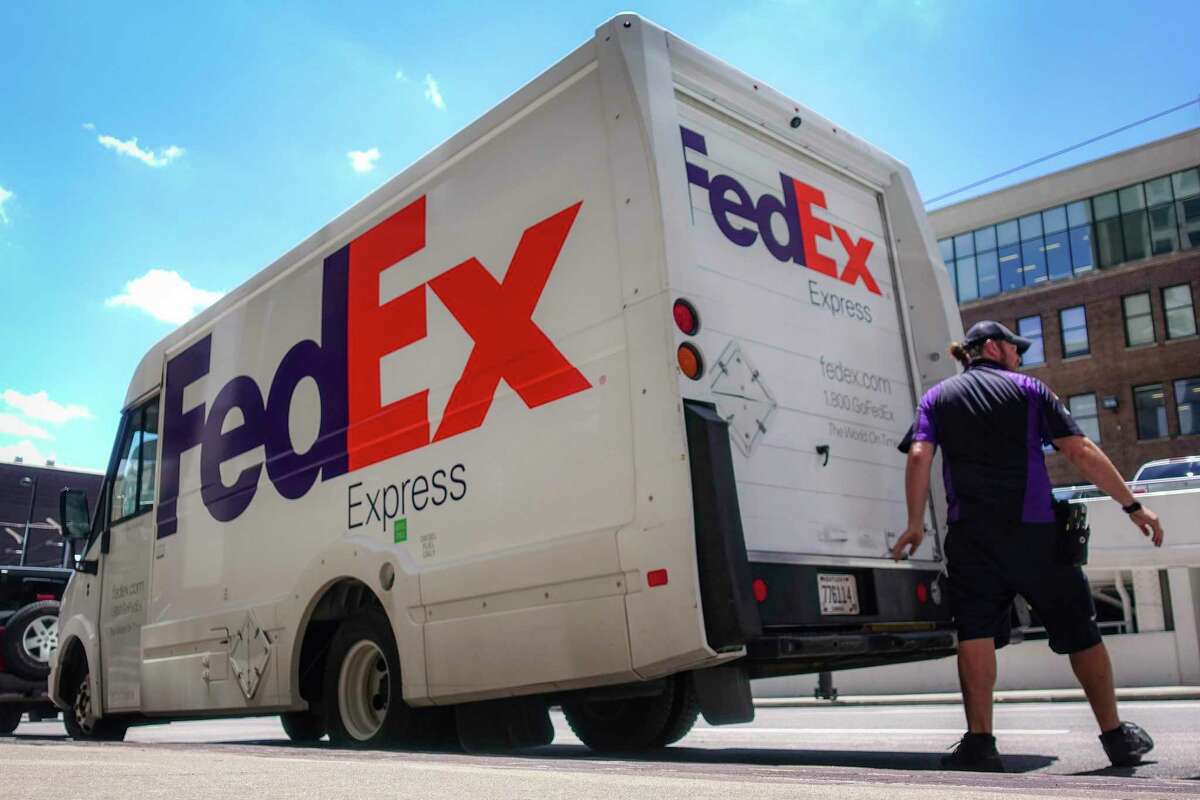 A FedEx delivery truck is loaded by an employee in downtown Cincinnati.