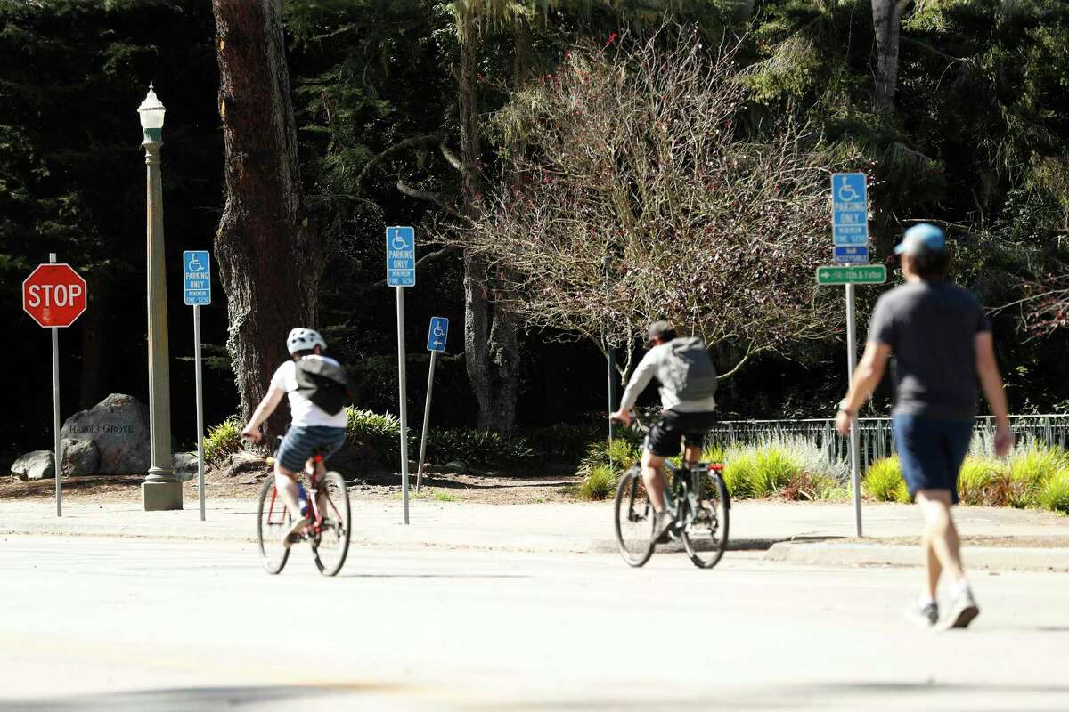 周一，骑自行车的人经过约翰·f·肯尼迪大道第八大道以西的残疾人停车位。其中一项提议是允许第八大道以西的车辆再次通行。