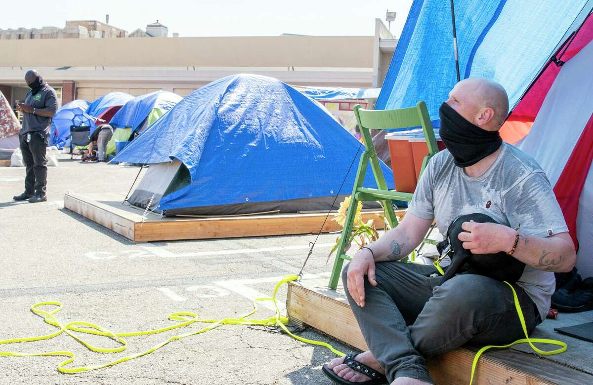 本杰明·朗莫尔和他的狗罗西在高夫街33号的帐篷里安全睡觉。2021年9月21日，星期二，加利福尼亚州旧金山。该市计划在秋季为高夫街的无家可归者安装70个小屋，作为试点项目。这些房屋将是临时的，取代目前的45顶帐篷，目的是让人们骑自行车进入更永久的居住环境。