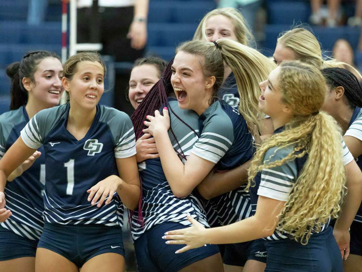 College Park volleyball players react after they win the third set of a District 13-6A volleyball match at College Park High School, Tuesday, Sept. 21, 2021, in The Woodlands.